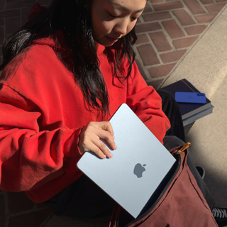 Een student bergt MacBook Air op in een rugzak